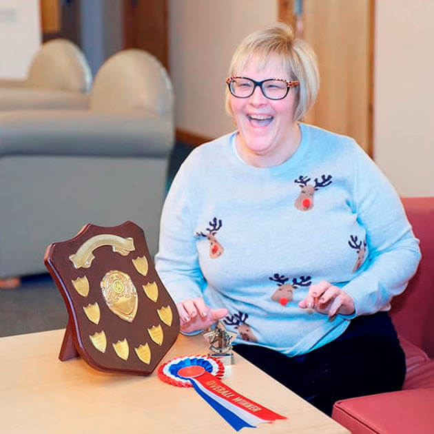 smiling woman showing her awards